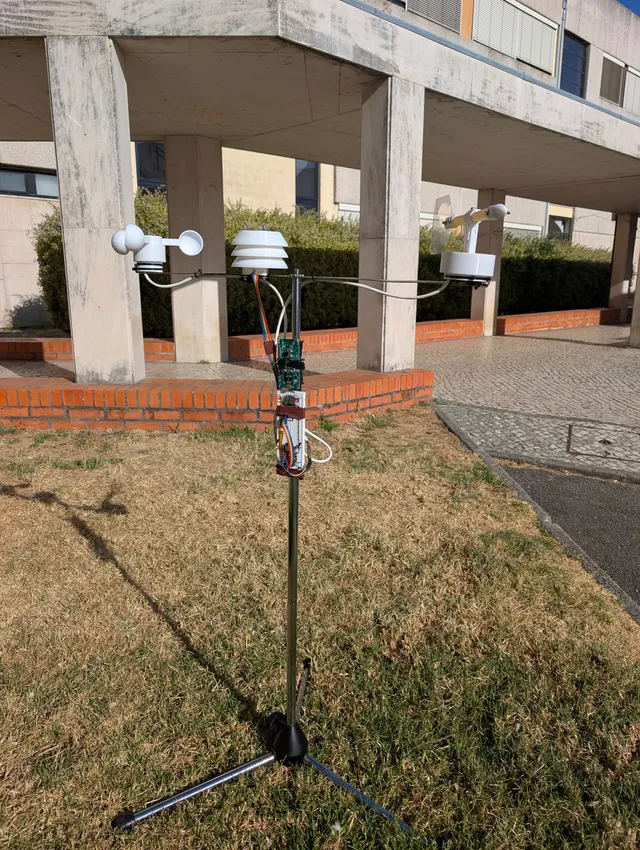 The assembled weather station outdoors, with a cup anemometer, shielded BME280, wind vane, and electronics mounted on a tripod.